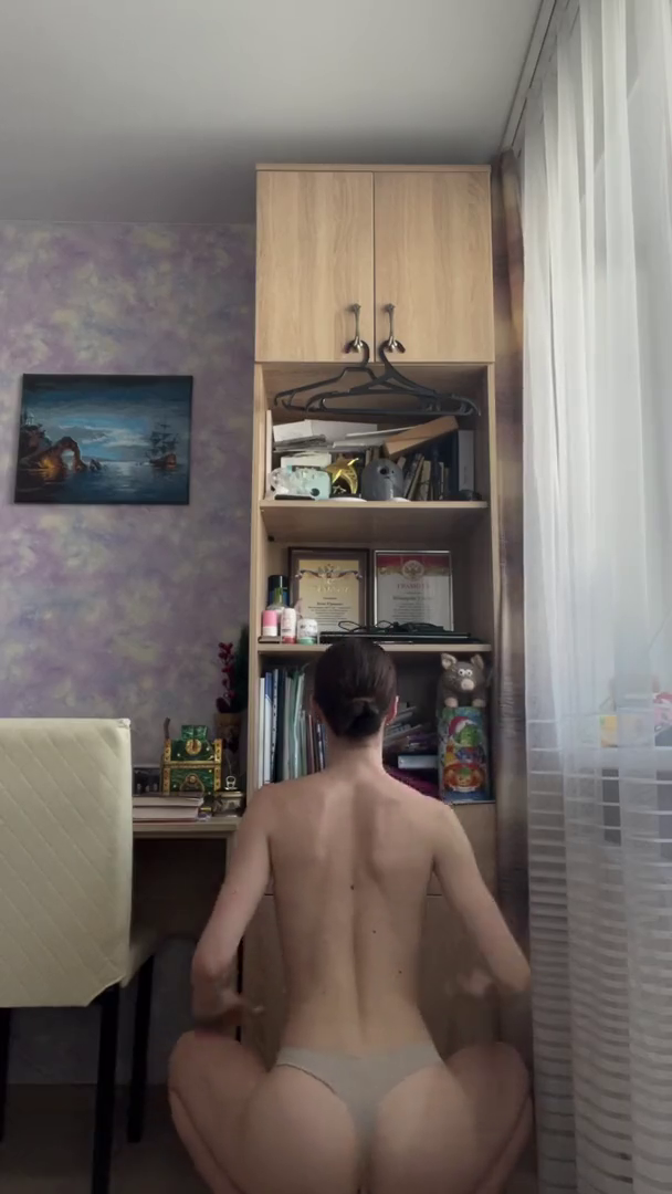 Красивая гимнастка в одних трусиках делает растяжку